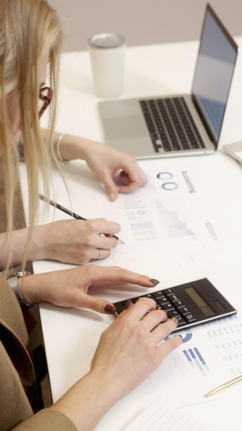 Accountant reviewing a business accounting summary with a calculator