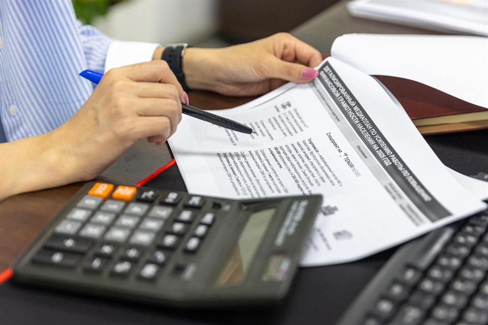 Reviewing an itemized compliance document with a calculator